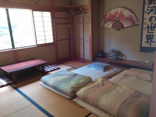 Matsuo House - Max 4 person Room Aki في زاو أونسين: سريرين في غرفة بها نافذتين