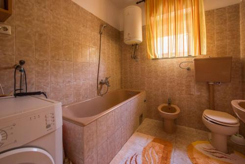 een badkamer met een bad, een toilet en een wastafel bij Apartments with a parking space Kastel Sucurac, Kastela - 16209 in Kaštela