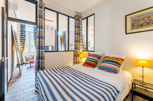 - une chambre avec un lit et quelques fenêtres dans l'établissement T2 Chic, Vue Vieux-Port et Notre Dame, Atypique, Calme, Clim, 48M2, Accès autonome avec code, à Marseille
