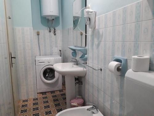 a bathroom with a toilet sink and a washing machine at Apartments with parking space Moscenicka Draga, Opatija - 16123 in Mošćenička Draga