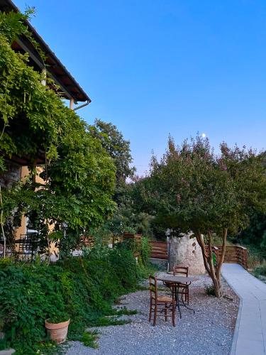 a table and chairs in a garden next to a building at B&B La Fucinaia Pet Friendly Adults only in Campiglia Marittima
