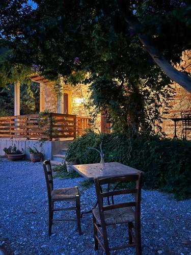 a table and two chairs in a yard with a tree at B&B La Fucinaia Pet Friendly Adults only in Campiglia Marittima