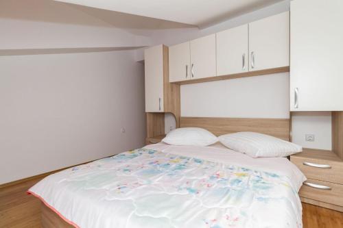 a bedroom with a large bed with white cabinets at Apartment Vodice 16249c in Vodice