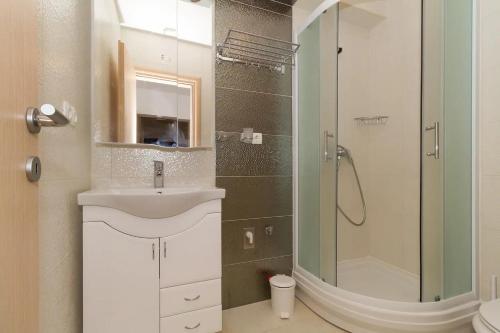 La salle de bains est pourvue d'un lavabo et d'une douche. dans l'établissement Apartments by the sea Vodice - 16249, à Vodice