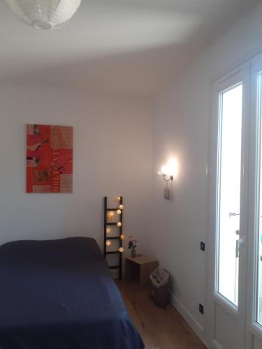 1 dormitorio con cama y ventana en chambre au calme haute ville en Auch