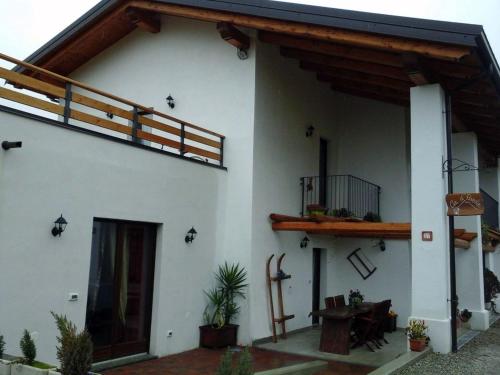 a white house with a porch and a balcony at Bed and Breakfast Ca D'Pandin in Peveragno