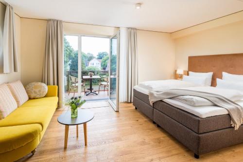 a hotel room with a bed and a couch at Parkhotel Jever in Jever