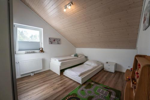 a attic room with two beds and a window at Seestern 1 - Nordhorn - a69856 in Nordhorn