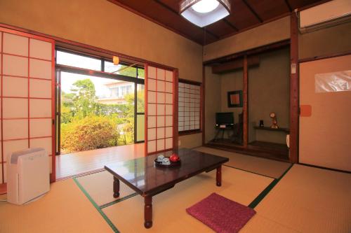 sala de estar con mesa y ventana grande en ootaryokan, en Kuroki