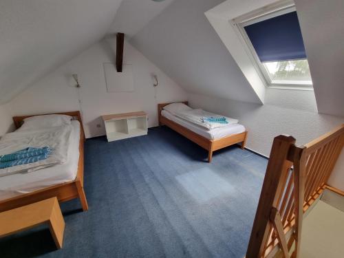 Vadersdorfにある"Ferienhaus Vadersdorf" Wohnung 2のベッド2台と窓が備わる小さな客室です。