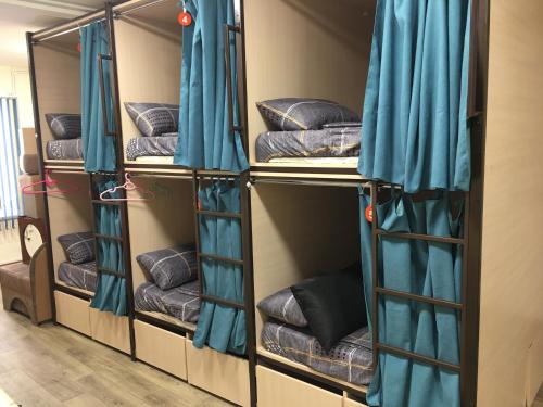 a room with four bunk beds with blue curtains at Bonvenon capsule Hostel in Yerevan