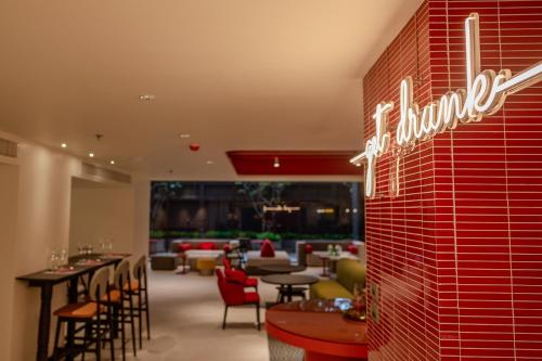 a restaurant with tables and chairs and a sign on a wall at Oakwood Studios Sukhumvit Bangkok in Bangkok