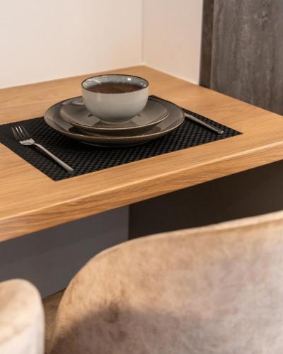 ヴォロスにあるEmpress Luxury Residencesのテーブルの上に皿が置かれたコーヒーカップ