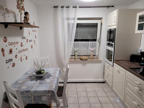 a kitchen with a table and a window in it at Neues Schwalbennest 26 Haus in Büsum