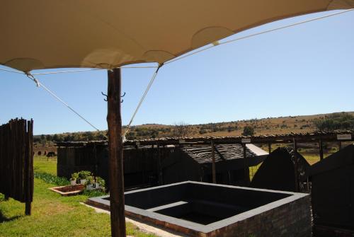 an open umbrella in a yard with a field at Grotto to Gravel in Magaliesburg