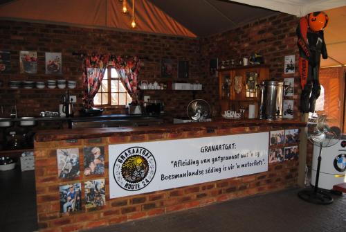 a bar with a sign on a brick wall at Grotto to Gravel in Magaliesburg