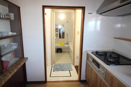 a kitchen with a shower and a door to a bathroom at 海と湖が近い一軒家　”民泊あばしりの家” in Kitahama