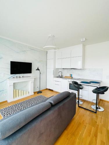 a living room with a couch and a table and a kitchen at White Pearl Studio with parking in Holešovice in Prague