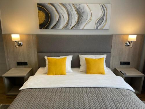 een slaapkamer met een bed met 2 gele kussens bij Hotel Complex Ukraine in Loetsk