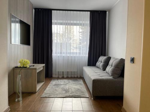 a living room with a couch and a window at Hotel Complex Ukraine in Lutsk