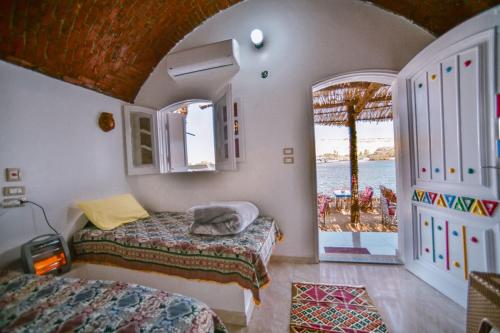 a bedroom with two beds and a view of the ocean at Kafana Guest House Nile View in Aswan