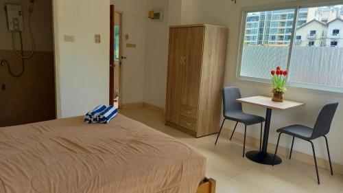1 Schlafzimmer mit einem Bett, 2 Stühlen und einem Tisch in der Unterkunft K2 Seaside Suites in Pattaya South