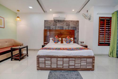 a bedroom with a large bed and a couch at FabHotel Vardhan House in Pune