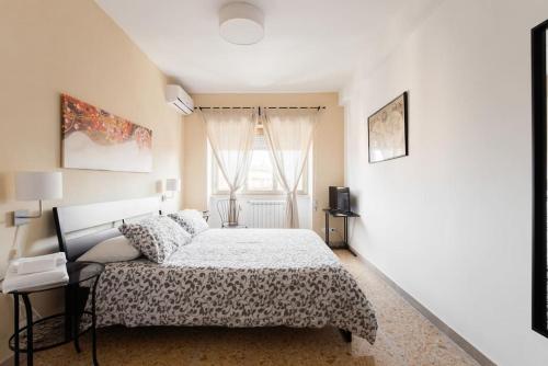 een witte slaapkamer met een bed en een raam bij Casa Giramondo in Rome