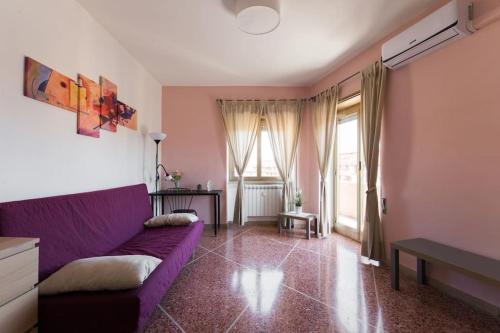 een woonkamer met een paarse bank en ramen bij Casa Giramondo in Rome