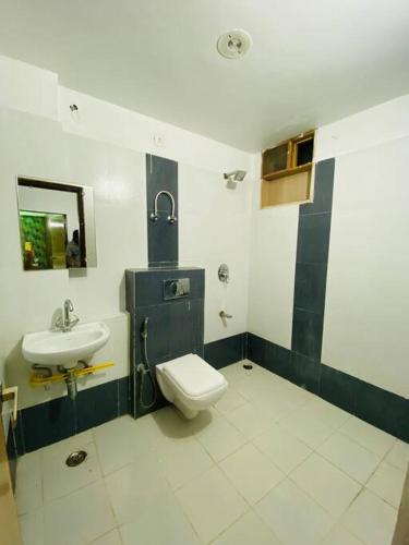 La salle de bains est pourvue de toilettes et d'un lavabo. dans l'établissement 2 bhk fully furnished luxurious private apartment, à Jaipur