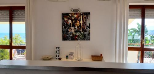 a white room with windows and a picture on the wall at WHITE LOTUS Apartment in Taormina