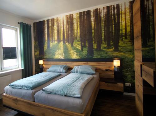 1 dormitorio con 2 camas en un mural del bosque en Ferienwohnung Busch en Bad Sachsa