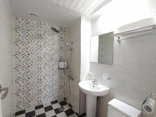 La salle de bains est pourvue d'un lavabo, de toilettes et d'une douche. dans l'établissement Fellisia Hotel, à Seogwipo