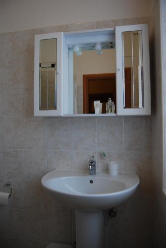 a bathroom with a white sink and a mirror at Le Querce in Curtatone