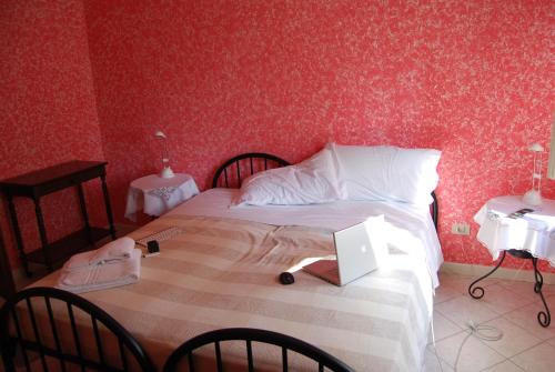 a bedroom with a bed with a laptop on it at Le Querce in Curtatone