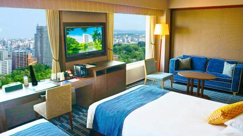 札幌市にあるプレミアホテル 中島公園 札幌のベッド、デスク、窓が備わるホテルルームです。