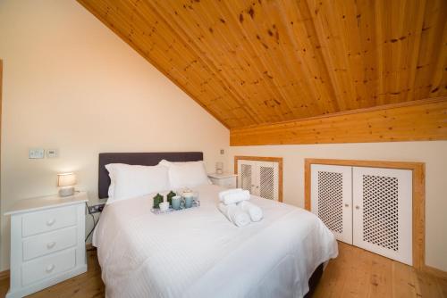 a bedroom with a white bed with two stuffed animals on it at Finest Retreats - Puddleduck 
