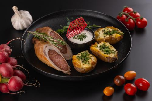 a black plate of food with bread and potatoes and tomatoes at Hotel Restaurant Park in Miercurea-Ciuc