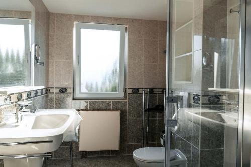 La salle de bains est pourvue d'un lavabo, de toilettes et d'une fenêtre. dans l'établissement mit Meerblick und Balkon, gratis Nutzung vom AHOI Erlebnisbad und Sauna in Sellin - Meeresblick FeWo 29, à Göhren
