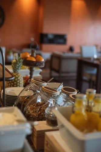 une table avec des bocaux de nourriture et une assiette d'oranges dans l'établissement MW Douro Wine & Spa, à Santa Marta de Penaguião
