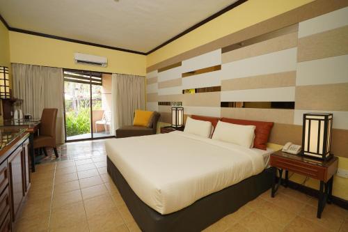een slaapkamer met een groot bed en een woonkamer bij Holiday Villa Beach Resort Cherating in Cherating