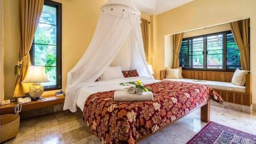 a bedroom with a large bed with a canopy at Villa Khao Phaengma in Wang Nam Khieo