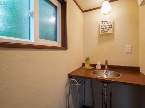 a bathroom with a sink and a sign on the wall at 森と湖の楽園ＷorkshopＣampＲesort in Fujikawaguchiko