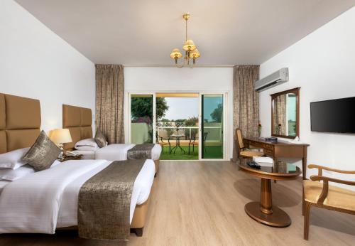 a hotel room with two beds and a desk at Airport Hotel in Abha