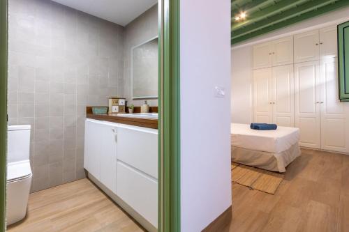 een badkamer met een wastafel en een bed in een kamer bij Charming apartment at La Alameda Seville City Center by Oui Sevilla in Sevilla