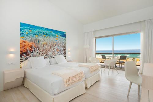 1 dormitorio con 1 cama y una pintura del océano en Iberostar Selection Fuerteventura Palace, en Morro del Jable