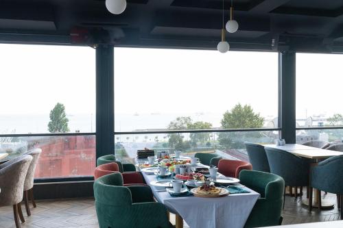 Un comedor con mesa y sillas y ventanas. en Costera Hotel, en Estambul