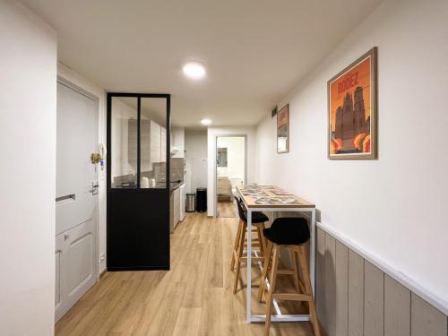 a kitchen with a table and stools in a room at Le Place Du Bourg Appartement T2 Centre Historique Rodez in Rodez