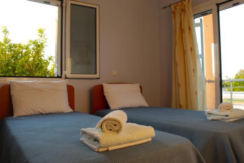 Duas camas com toalhas num quarto com janela em VILLA DIAMOND Κουρούτα Αμαλιαδος em Amaliada