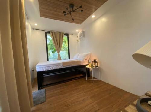a small bedroom with a bed and a window at Casita Blanca Jala-Jala - Tiny House & Farm Stay in Jalajala